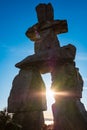 Figure of inukshuk on the seacoast against the sunset. Inukshuk at English Bay Beach in Vancouver BC Royalty Free Stock Photo