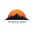 Silhouette of a jagged mountain range in front of a vibrant orange and red sunset. Royalty Free Stock Photo
