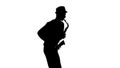 Silhouette jazzman performs solo on saxophone in a slow motion