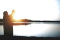 Silhouette of Jesus Christ with his hands up and the sun shining in the background Royalty Free Stock Photo