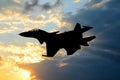 Silhouette of jet fighter in cloudy sky at sunrise Royalty Free Stock Photo