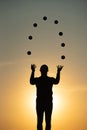 Silhouette of juggler with balls on colorful sunset Royalty Free Stock Photo