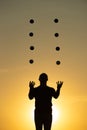 Silhouette of juggler with balls on colorful sunset Royalty Free Stock Photo