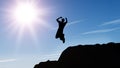 Silhouette of the jumping man from a rock