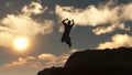 Silhouette of the jumping man from a rock