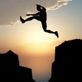 Silhouette of the jumping man from a rock