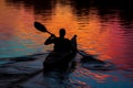 silhouette of a kayaker at sunset, water reflecting colors