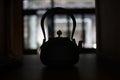 Silhouette of a kettle in a dark room