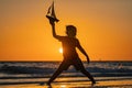 Silhouette of kid playing with toy seailing boat on sunset sea. Kid with toy boat in sea water on summer vacation Royalty Free Stock Photo