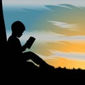 Silhouette of kid reading a book under the tree during beautiful sunset Royalty Free Stock Photo