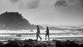 Silhouette of Kids playing in Goa seashore featuring rocks and sea in Black and white Royalty Free Stock Photo