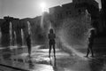 Silhouette of kids playing in a water fountain