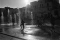 Silhouette of kids playing in a water fountain