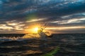 Silhouette of kitesurfer riding at the ocean in sunset condition with sun star and lens flare