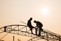 Silhouette labor on the roof in the sunset