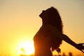 Silhouette of a lady breathing fresh air at sunset