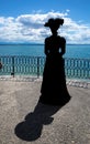 Silhouette - lady from the old times on the shores of the lake