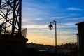 Silhouette of lamp with bird on background of the city and the twilight blue sky.clouds Royalty Free Stock Photo