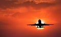 Silhouette of landing aircraft and red sky with sun Royalty Free Stock Photo