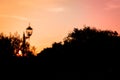 Autumn Silhouette: Lantern Amidst Colorful Sunset Sky