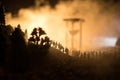 Silhouette of a large crowd of people in forest at night standing against a big hourglass with toned light beams on foggy backgrou Royalty Free Stock Photo