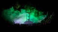 Silhouette of a large crowd of people in forest at night standing against a big hourglass with toned light beams on foggy backgrou Royalty Free Stock Photo