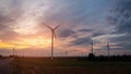 Silhouette large wind turbines at sunrise taken from the air.