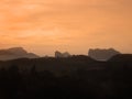 Silhouette layer tropical mountain hill landscape at sunset with gold orange yellow sky and clouds Royalty Free Stock Photo