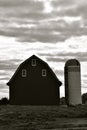 Silhouette of ld barn and silo in black and white