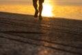 Silhouette of legs athlete running at the sunrise on river coast