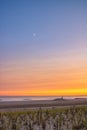 Silhouette of a lifeguard on the beach at sunset, with waves crashing in the background.