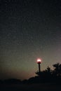 Silhouette of the Lighthouse and trees against the background of the starry sky Royalty Free Stock Photo