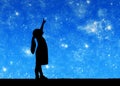 Silhouette, little baby girl looking at starry sky and showing thumb up