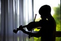 silhouette Little boys play and practice violin in music class room