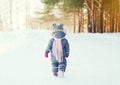 Silhouette little child walking in forest on a winter