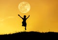 Silhouette little girl jumping to sky on sunset with full moon. Royalty Free Stock Photo