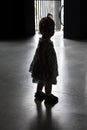 Silhouette of a little girl left by her parents in a shelter. Concept: abandoned and lost children, orphans and loneliness. Royalty Free Stock Photo