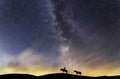 Silhouette of a lone rider with a horses walking on a hill in the starry night. Behind him is the beautiful bright Milky Way galax Royalty Free Stock Photo