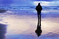 The silhouette of a lone walker on a secluded beach.