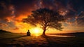 Silhouette of lonely human under old majestic tree at evening meadow during incredible sunset with rays of golden sun