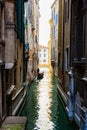 Silhouette of a lonely sad gondolier in a gondola without passengers in a narrow side channel in Venice, Italy. No people because Royalty Free Stock Photo