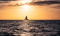 Silhouette of a lonely sailboat on the horizon at sunset. Royalty Free Stock Photo