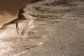 Silhouette of lonely walking woman on the beach with sunlight reflection