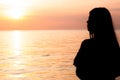 Silhouette of a lonely woman standing near the seashore and seeing the sunset. Depression, unhappy, stressed and anxiety disorder Royalty Free Stock Photo