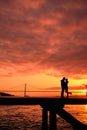 Couples kissing on the bridge at sunset Royalty Free Stock Photo