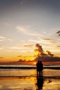 Silhouette lovers relax on the beach in color of sunset