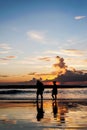 Silhouette lovers relax on the beach in color of sunset