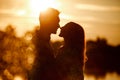silhouette of loving couple hugging on the lake at sunset. Beautiful young couple in love walking on the shore of the Royalty Free Stock Photo