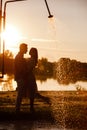 silhouette of loving couple hugging on the lake at sunset. Beautiful young couple in love walking on the shore of the Royalty Free Stock Photo