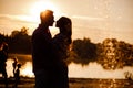 silhouette of loving couple hugging on the lake at sunset. Beautiful young couple in love walking on the shore of the Royalty Free Stock Photo